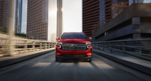 A red 2022 Chevrolet Tahoe driving down a city road.