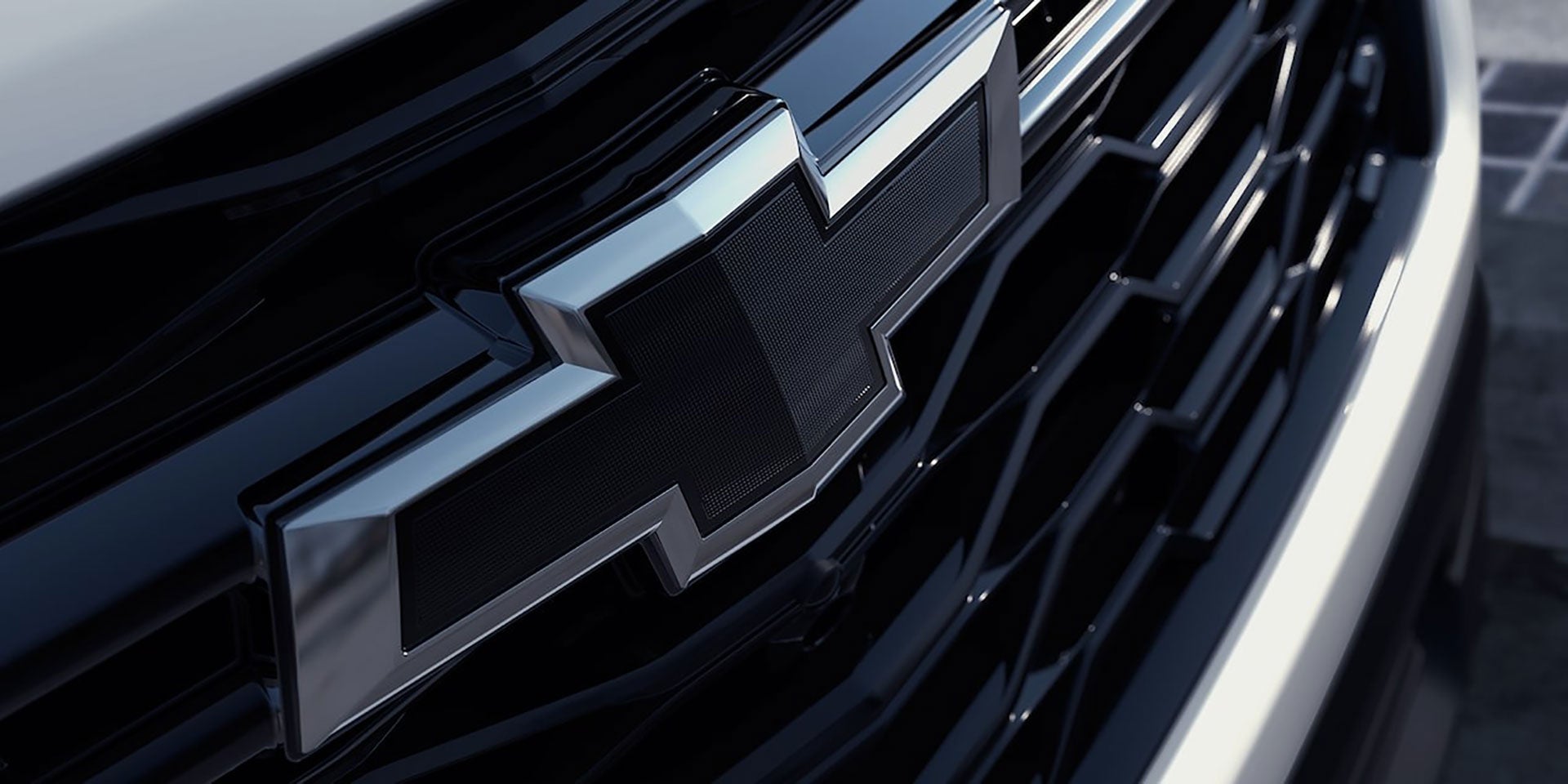 Close-up of a black Chevrolet bowtie emblem on a vehicle grille.